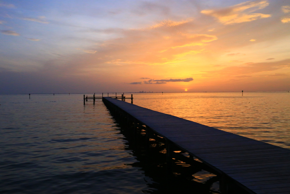 pier on the water with the sunsetting in the background