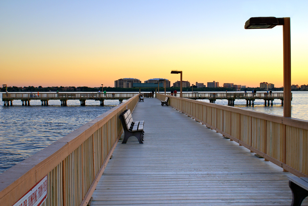 pier with benches and sun setting in the background